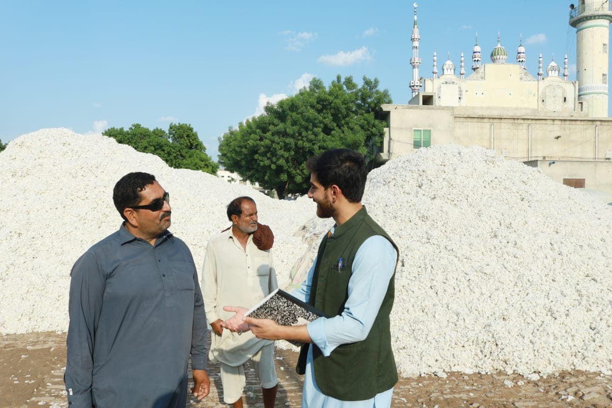 Briefing a mandi contact on-site, notebook in hand