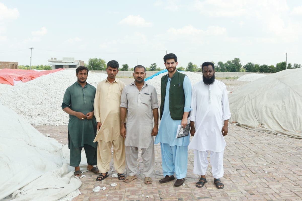 The on-ground field team standing among cotton arrivals
